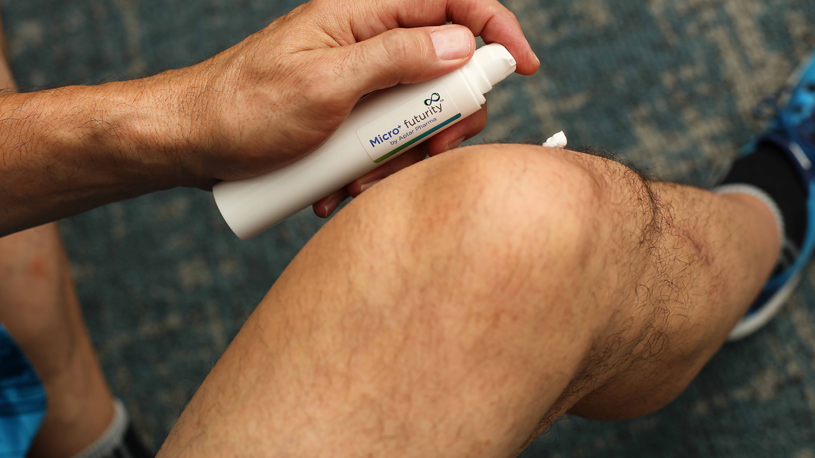 User applying dermal formulation from a recyclable Airless+ spray pump designed for sustainable dispensing.